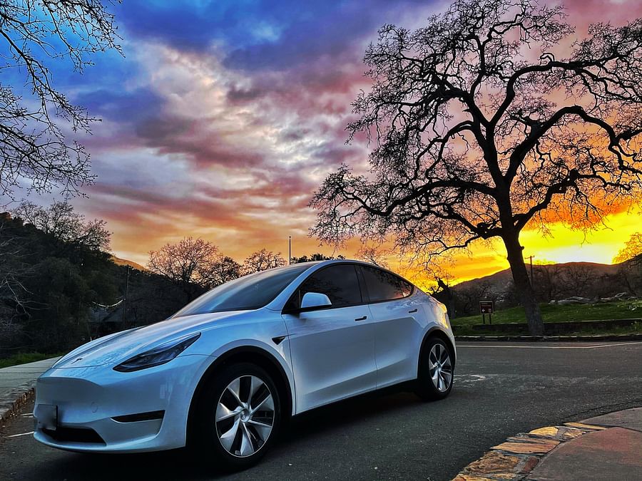 Tesla car parked with a beautiful sunset in the background